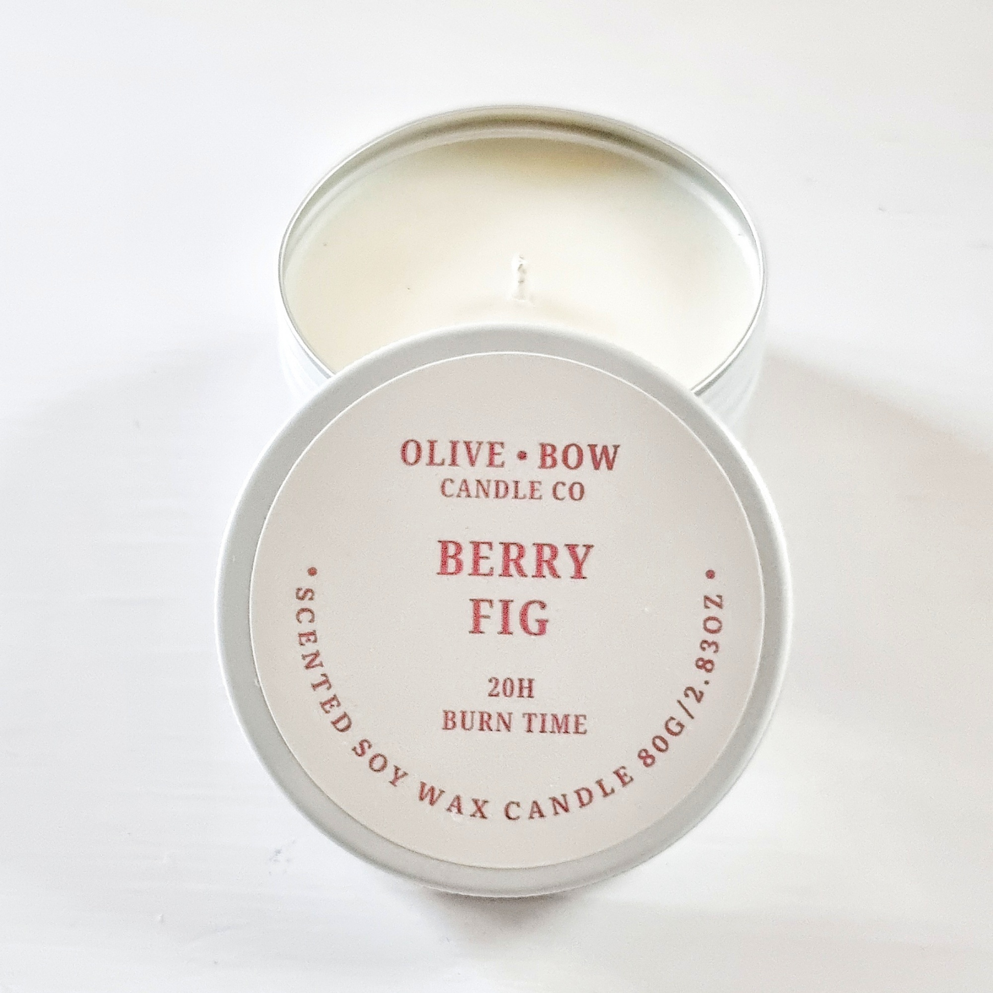 Soy candle in a tin with 'Olive Bow Candle Co' branding on a white background with the scent 'Berry Fig'