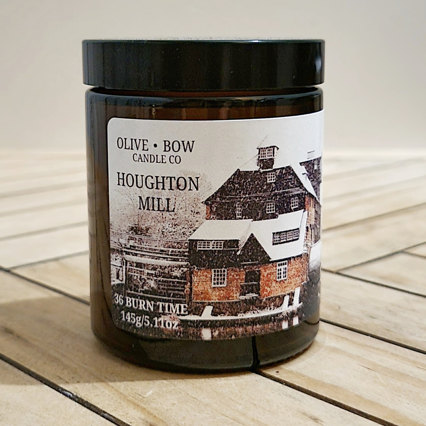 Candle jar with a label featuring 'Houghton Mill' on a wooden surface