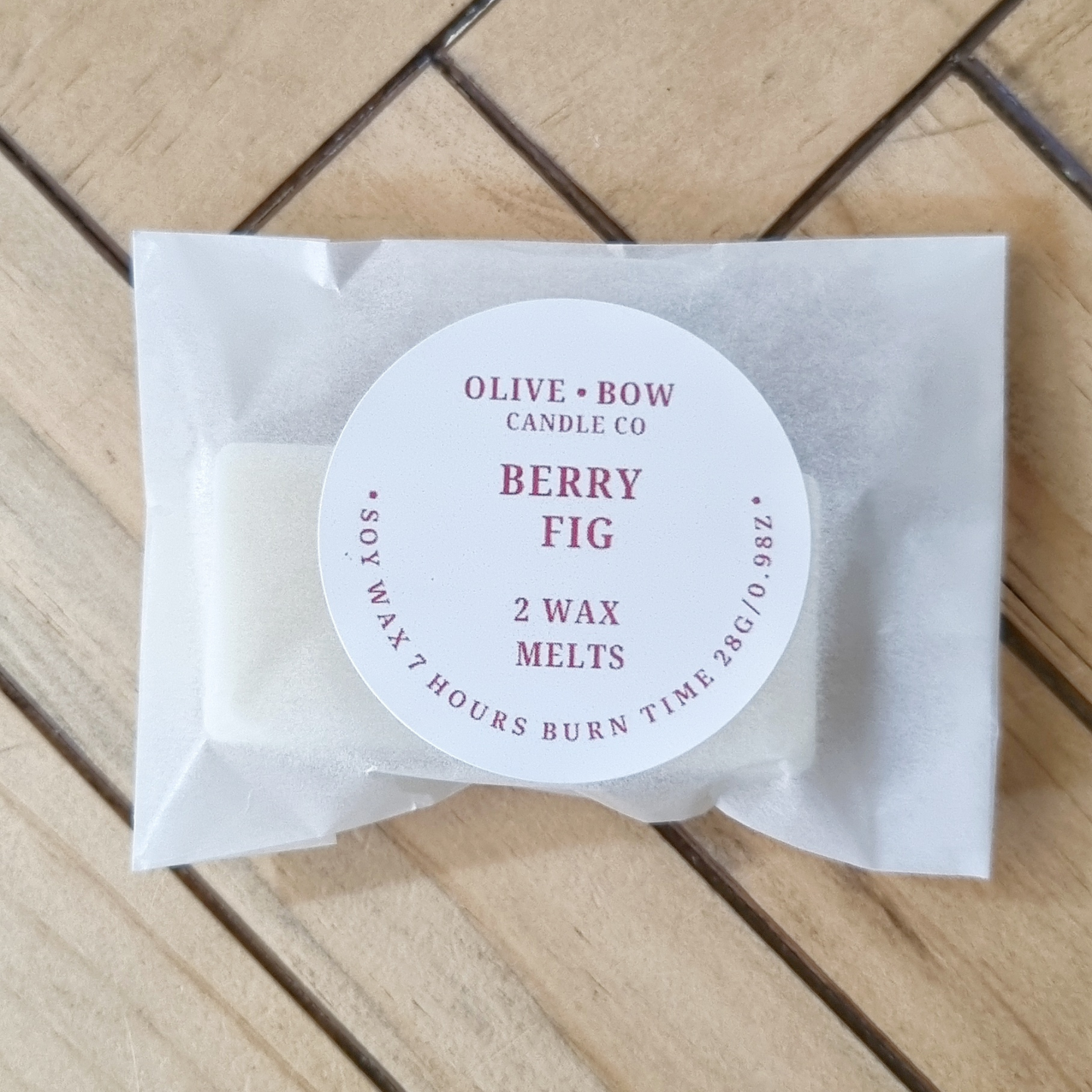 Pack of Olive & Bow Candle Co. Berry Fig soy wax melts on a wooden surface
