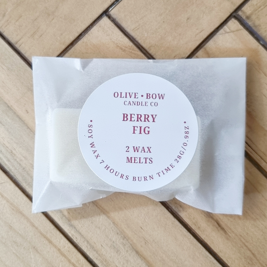 Pack of Olive & Bow Candle Co. Berry Fig soy wax melts on a wooden surface